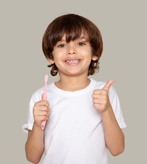 Smiling child with toothbrush giving thumbs up.