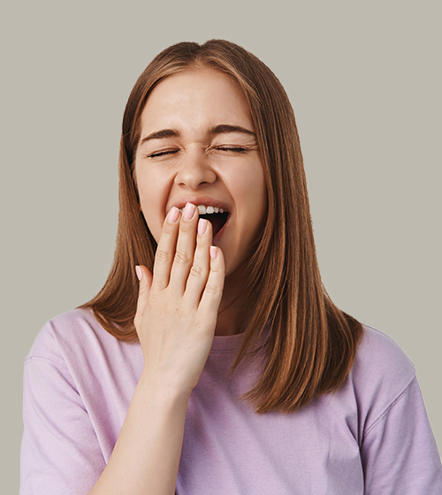 Woman yawning, tired or bored, neutral background.